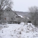 Huis vanuit de tuin met sneeuw